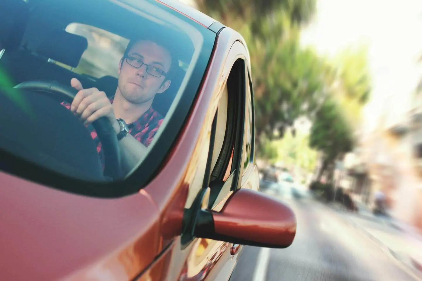 homem dirigindo veículo, olhando retrovisor, representando Bradesco Seguro Auto