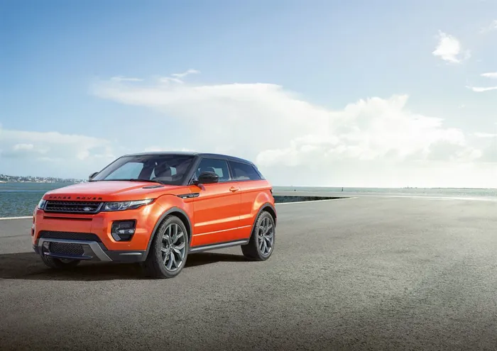 carro range rover evoque de cor laranja em uma pista