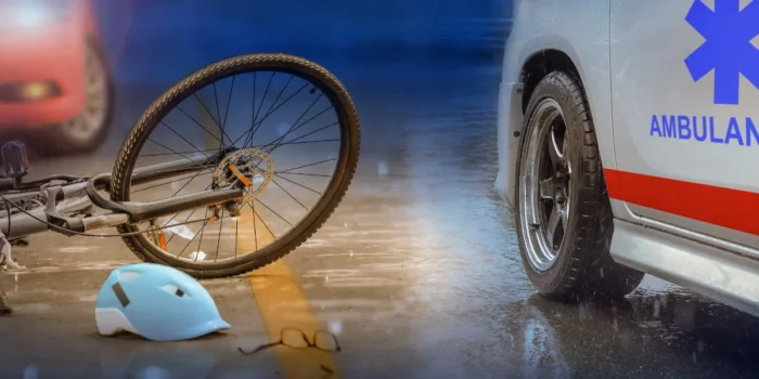 uma bicicleta caída no chão e uma ambulância ao lado representando que bebida e direção não combinam