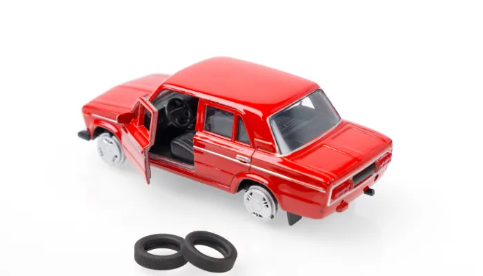 carro de brinquedo vermelho representando a perda total de um carro roubado financiado sem seguro