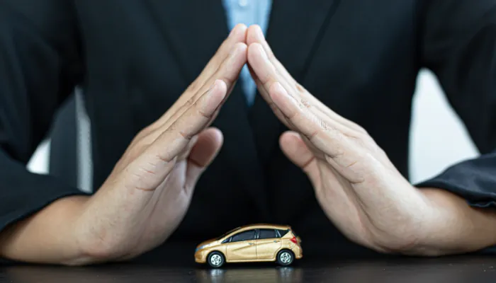 carro de brinquedo em uma mesa seguro por duas mãos
