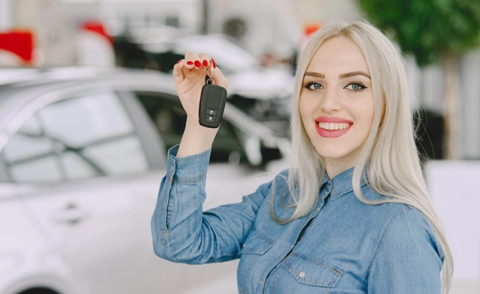 Proprietária exibe chave do seu carro com garantia estendida.
