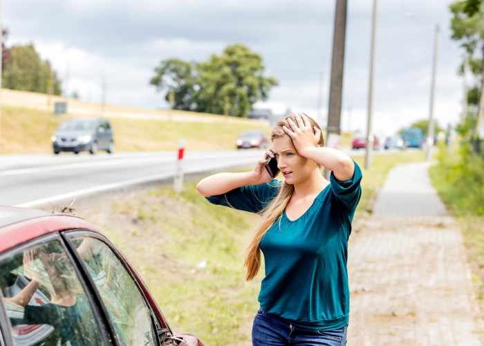 Mulher com expressão de desespero fala ao telefone para comunicar a ocorrência de um sinistro.