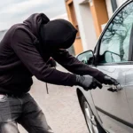 Criminoso encapuzado tenta arrombar carro. Falando sobre seguro contra roubo de carro.