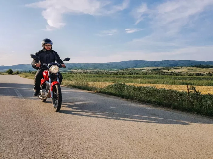 Homem pilota moto em rodovia. Explicando a partir de quantas cilindradas precisa de habilitação.