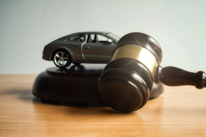Martelo de juiz e miniatura de carro na cor cinza escuro. Falando sobre seguro para carros leilão de financiadora.