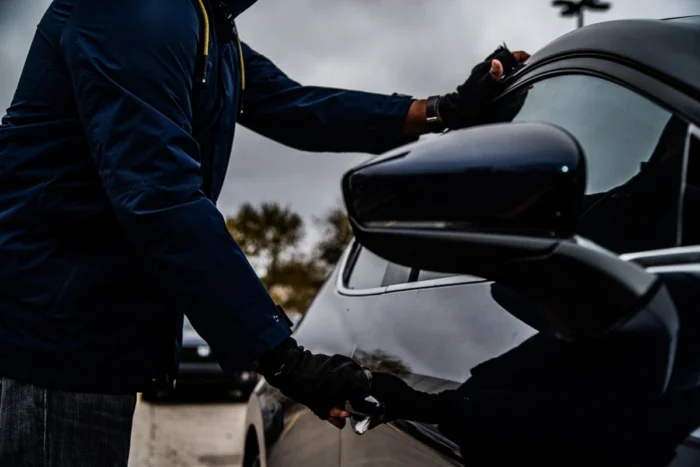 Criminoso tentando arrombar carro. Falando sobre os carros mais roubados na bahia.