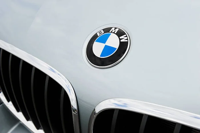 Zoom em frente de carro da BMW, pegando a logomarca da montadora. Falando sobre o seguro bmw.