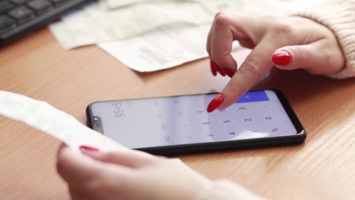 Pessoa calculando valores no celular